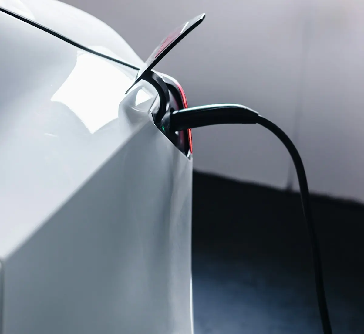 Auto eléctrico blanco conectado a un cargador