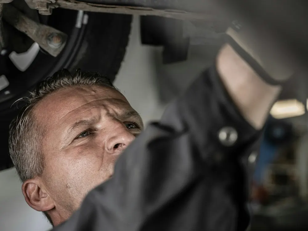 Mecánico trabajando debajo de un auto en un taller