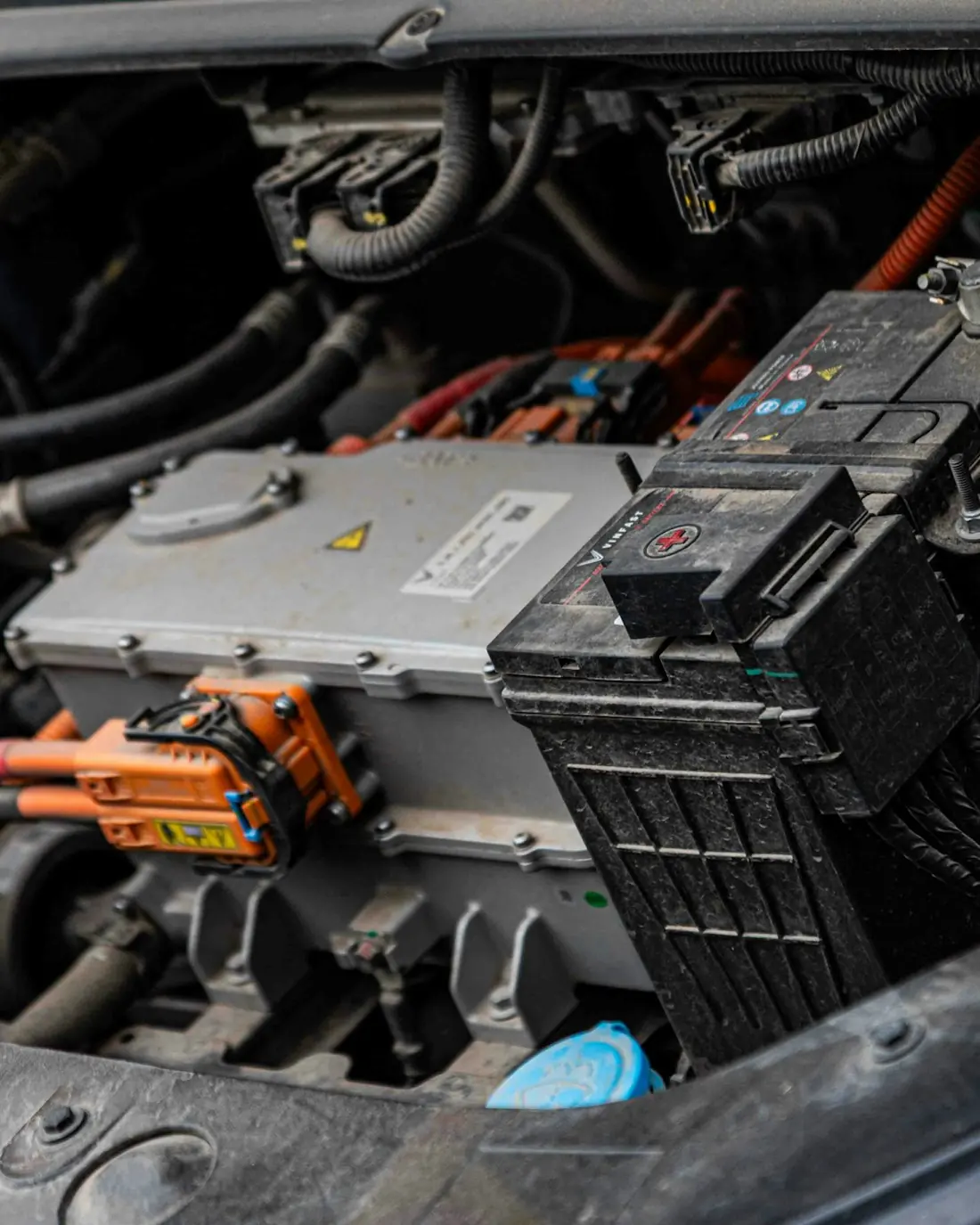 Compartimento de un auto eléctrico con cables naranja de alta tensión