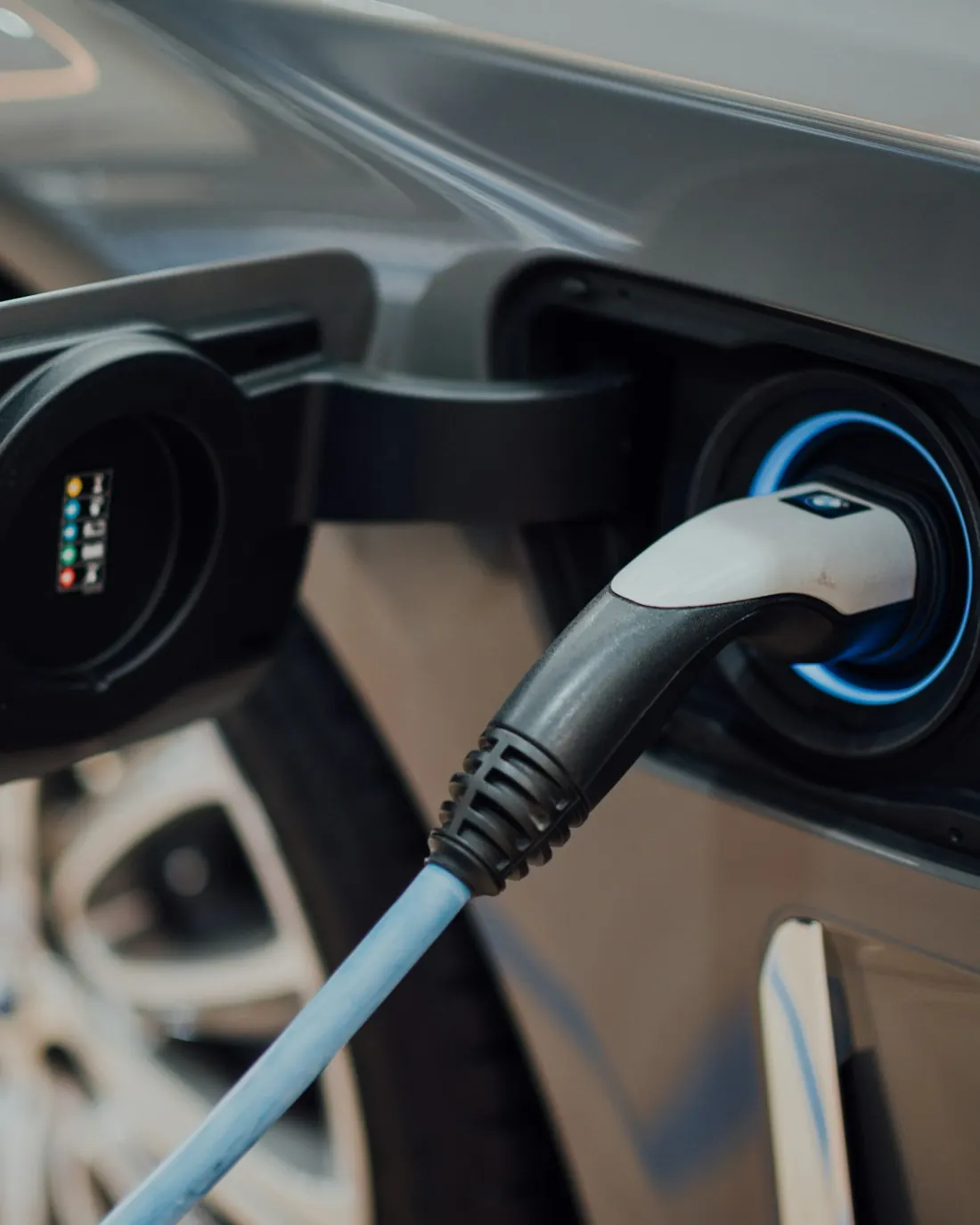 Conector de carga enchufado en el puerto de un auto eléctrico
